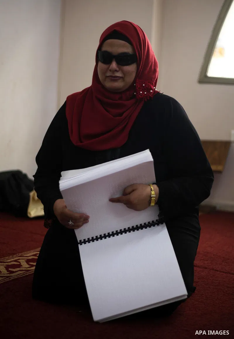 A Palestinian blind girl reads and memorise the holy Quran in braille at Dar al-Quran and Sunnah in Gaza city, on July 23, 2018. Photo by Mahmoud Ajour