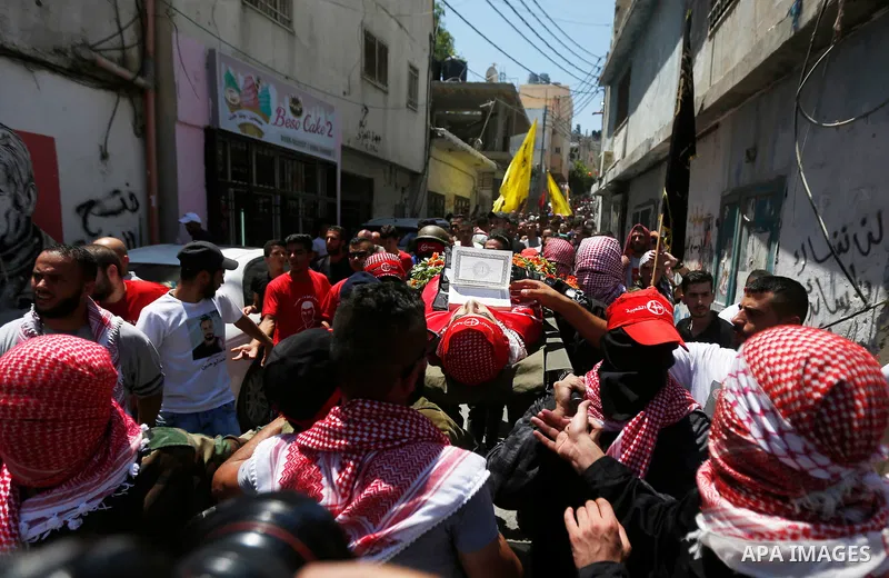 Mourners carry the body of Palestinian teenager Arkan Mezeher, who was killed by Israeli soldiers during a raid, during his funeral in Dheishe refugee camp, near West Bank city of Bethlehem on July 23, 2018. Photo by Wis...