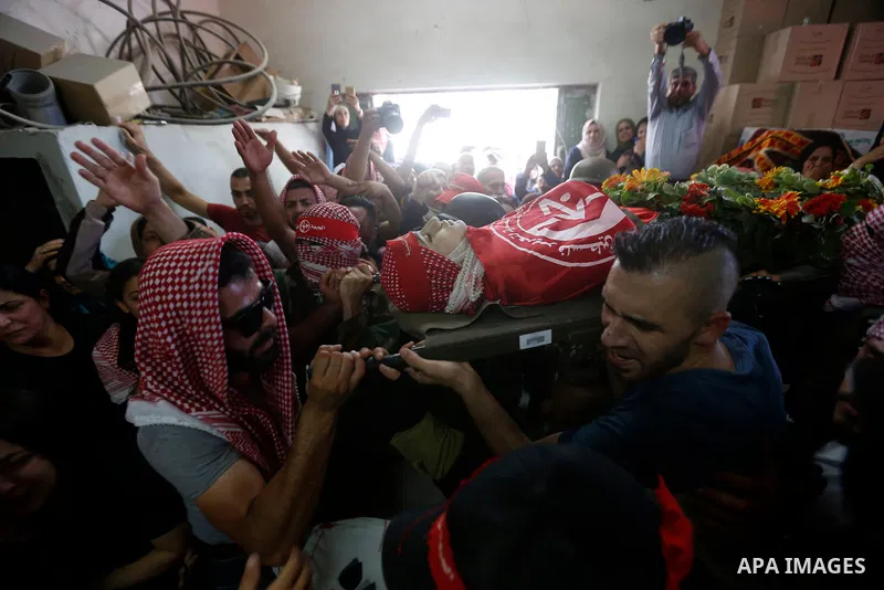 Mourners carry the body of Palestinian teenager Arkan Mezeher, who was killed by Israeli soldiers during a raid, during his funeral in Dheishe refugee camp, near West Bank city of Bethlehem on July 23, 2018. Photo by Wis...