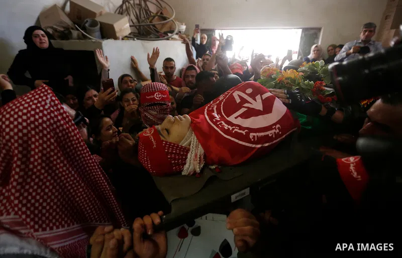 Mourners carry the body of Palestinian teenager Arkan Mezeher, who was killed by Israeli soldiers during a raid, during his funeral in Dheishe refugee camp, near West Bank city of Bethlehem on July 23, 2018. Photo by Wis...