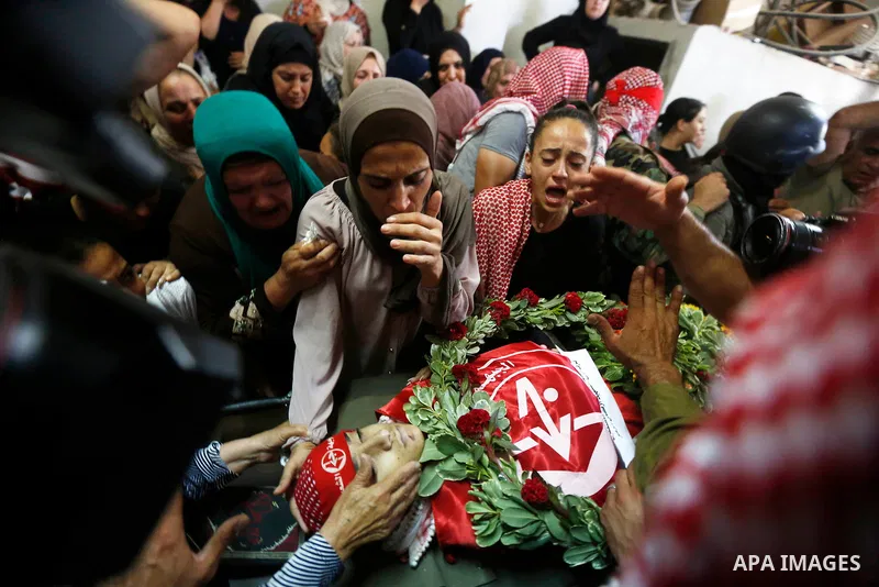 Relatives of Palestinian teenager Arkan Mezeher, who was killed by Israeli soldiers during a raid, mourn over his body during his funeral in Dheishe refugee camp, near West Bank city of Bethlehem on July 23, 2018. Photo...