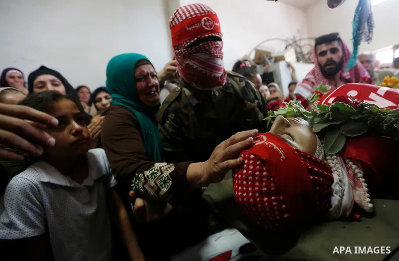 Relatives of Palestinian teenager Arkan Mezeher, who was killed by Israeli soldiers during a raid, mourn over his body during his funeral in Dheishe refugee camp, near West Bank city of Bethlehem on July 23, 2018. Photo...