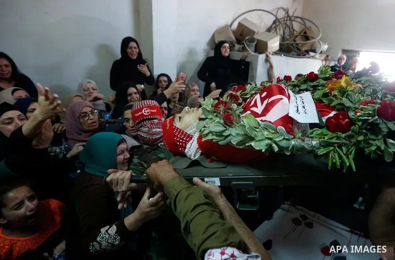 Relatives of Palestinian teenager Arkan Mezeher, who was killed by Israeli soldiers during a raid, mourn over his body during his funeral in Dheishe refugee camp, near West Bank city of Bethlehem on July 23, 2018. Photo...