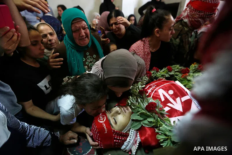 Relatives of Palestinian teenager Arkan Mezeher, who was killed by Israeli soldiers during a raid, mourn over his body during his funeral in Dheishe refugee camp, near West Bank city of Bethlehem on July 23, 2018. Photo...