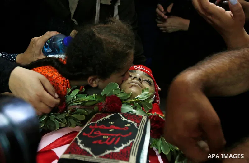 Relatives of Palestinian teenager Arkan Mezeher, who was killed by Israeli soldiers during a raid, mourn over his body during his funeral in Dheishe refugee camp, near West Bank city of Bethlehem on July 23, 2018. Photo...
