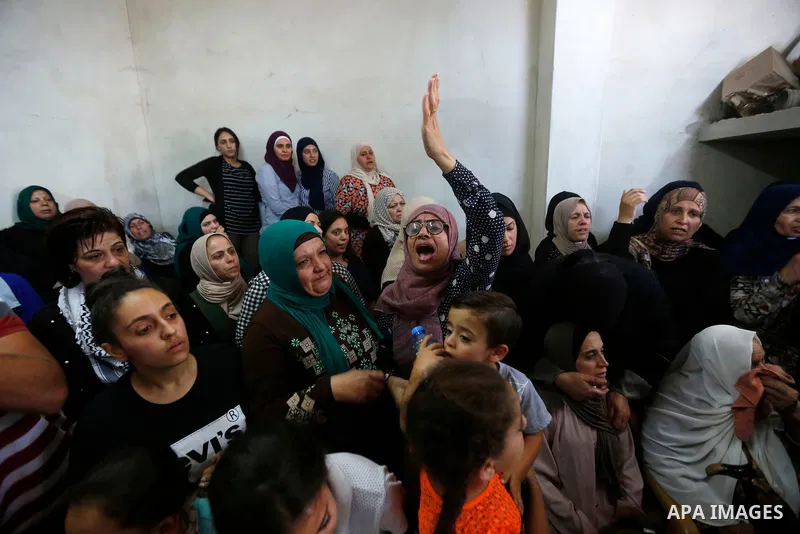 Relatives of Palestinian teenager Arkan Mezeher, who was killed by Israeli soldiers during a raid, mourn during his funeral in Dheishe refugee camp, near West Bank city of Bethlehem on July 23, 2018. Photo by Wisam Hashl...