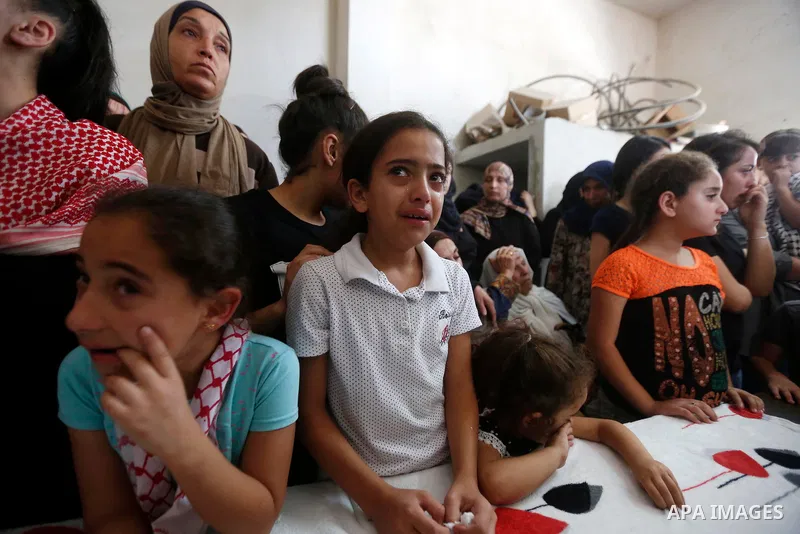 Relatives of Palestinian teenager Arkan Mezeher, who was killed by Israeli soldiers during a raid, mourn during his funeral in Dheishe refugee camp, near West Bank city of Bethlehem on July 23, 2018. Photo by Wisam Hashl...