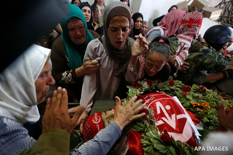 Relatives of Palestinian teenager Arkan Mezeher, who was killed by Israeli soldiers during a raid, mourn over his body during his funeral in Dheishe refugee camp, near West Bank city of Bethlehem on July 23, 2018. Photo...