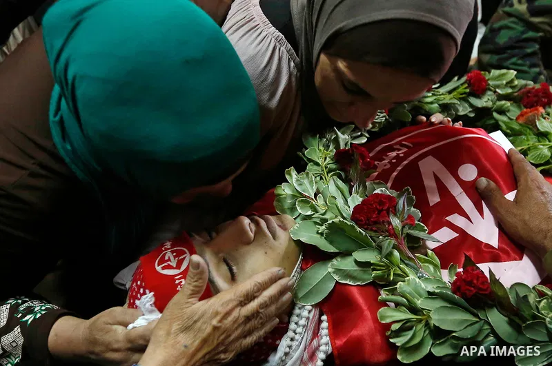 Relatives of Palestinian teenager Arkan Mezeher, who was killed by Israeli soldiers during a raid, mourn over his body during his funeral in Dheishe refugee camp, near West Bank city of Bethlehem on July 23, 2018. Photo...
