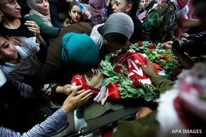 Relatives of Palestinian teenager Arkan Mezeher, who was killed by Israeli soldiers during a raid, mourn over his body during his funeral in Dheishe refugee camp, near West Bank city of Bethlehem on July 23, 2018. Photo...
