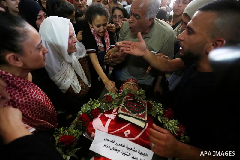 Relatives of Palestinian teenager Arkan Mezeher, who was killed by Israeli soldiers during a raid, mourn over his body during his funeral in Dheishe refugee camp, near West Bank city of Bethlehem on July 23, 2018. Photo...