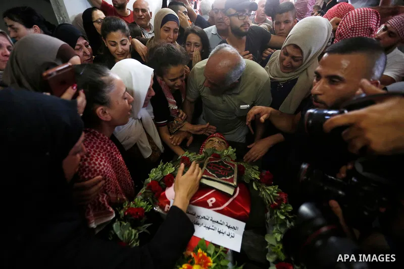 Relatives of Palestinian teenager Arkan Mezeher, who was killed by Israeli soldiers during a raid, mourn over his body during his funeral in Dheishe refugee camp, near West Bank city of Bethlehem on July 23, 2018. Photo...