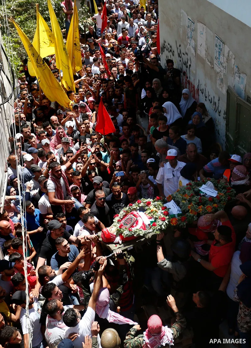 Mourners carry the body of Palestinian teenager Arkan Mezeher, who was killed by Israeli soldiers during a raid, during his funeral in Dheishe refugee camp, near West Bank city of Bethlehem on July 23, 2018. Photo by Wis...