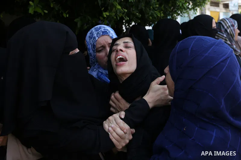 Relatives of Palestinian Karam Arafat,23, who died of wounds he sustained during clashes with Israeli troops, mourn during his funeral in Khan Younis in the southern of Gaza strip on July 23, 2018. Photo by Ashraf Amra