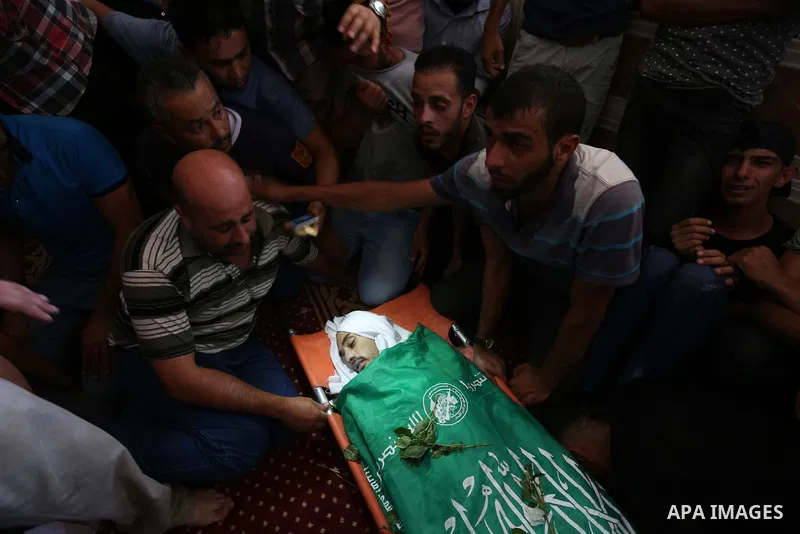 Relatives of Palestinian Karam Arafat,23, who died of wounds he sustained during clashes with Israeli troops, mourn over his body during his funeral in Khan Younis in the southern of Gaza strip on July 23, 2018. Photo by...