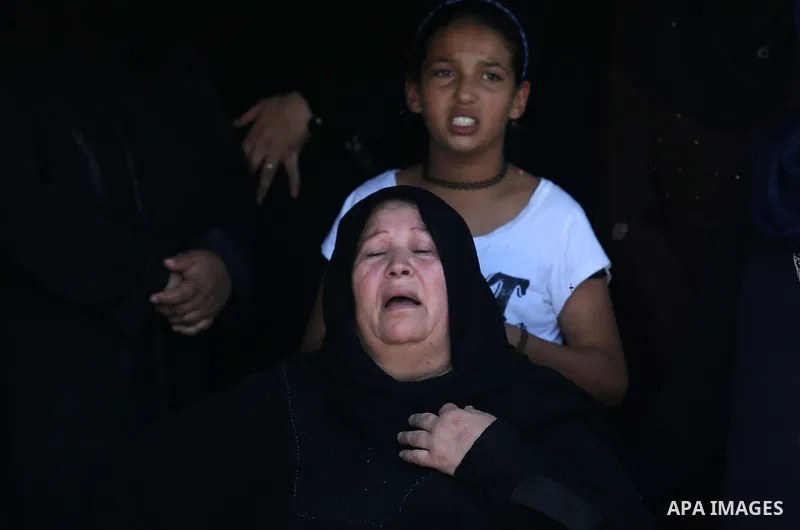 Relatives of Palestinian Karam Arafat,23, who died of wounds he sustained during clashes with Israeli troops, mourn during his funeral in Khan Younis in the southern of Gaza strip on July 23, 2018. Photo by Ashraf Amra