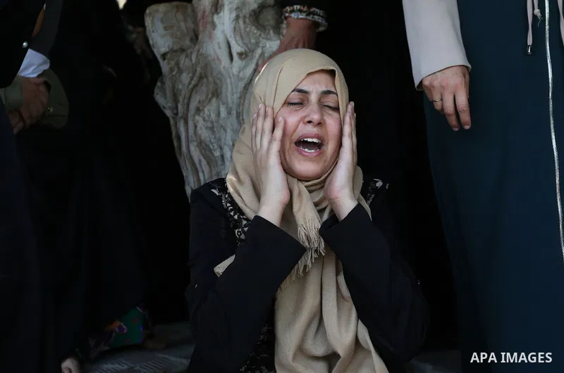 Relatives of Palestinian Karam Arafat,23, who died of wounds he sustained during clashes with Israeli troops, mourn during his funeral in Khan Younis in the southern of Gaza strip on July 23, 2018. Photo by Ashraf Amra