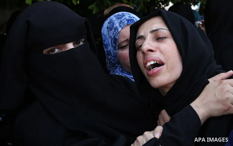 Relatives of Palestinian Karam Arafat,23, who died of wounds he sustained during clashes with Israeli troops, mourn during his funeral in Khan Younis in the southern of Gaza strip on July 23, 2018. Photo by Ashraf Amra