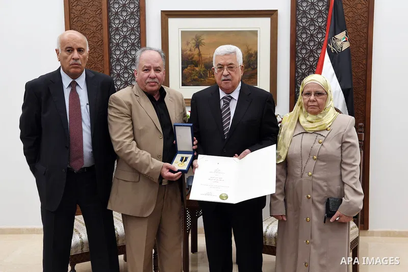 Palestinian President Mahmoud Abbas honors the families of martyrs in the West Bank city of Ramallah, on July 23, 2018. Photo by Thaer Ganaim