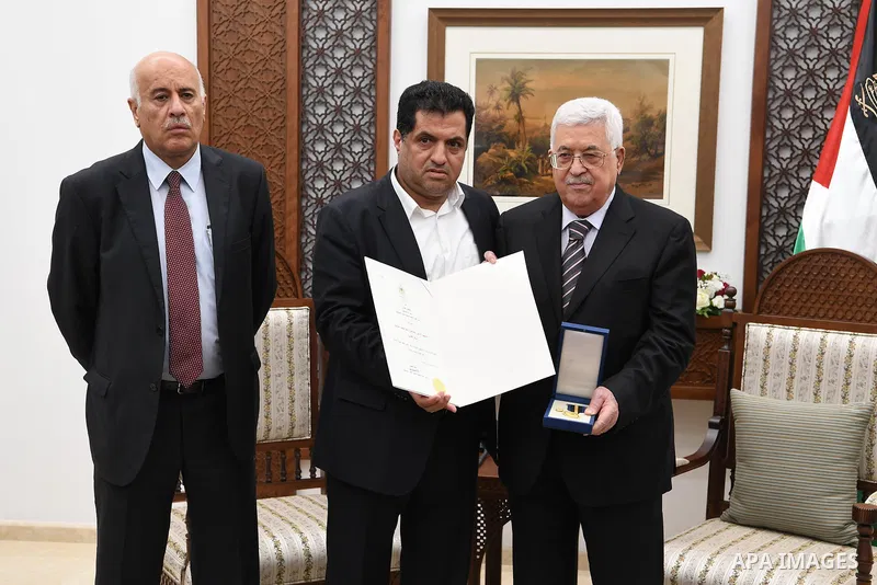 Palestinian President Mahmoud Abbas honors the families of martyrs in the West Bank city of Ramallah, on July 23, 2018. Photo by Thaer Ganaim