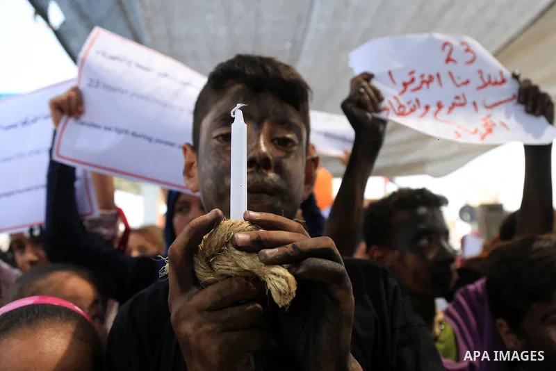 Palestinian children hold banners and candles during in a protest against the continued Israeli siege on the Gaza Strip, at Erez crossing, in the northern Gaza Strip on July 24, 2018. Photo by Dawoud Abo Alkas