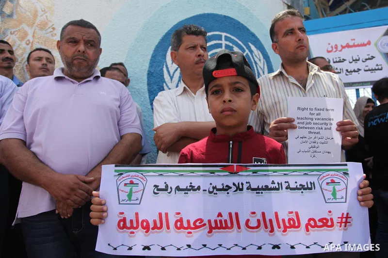 Palestinian employees of United Nations Relief and Works Agency (UNRWA) hold a sign during a protest against a U.S. decision to cut aid, in front of the headquarters UNRWA, in Gaza City on July 24, 2018. Photo by Mahmoud...