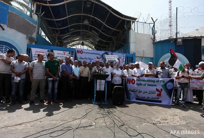 Palestinian employees of United Nations Relief and Works Agency (UNRWA) hold a sign during a protest against a U.S. decision to cut aid, in front of the headquarters UNRWA, in Gaza City on July 24, 2018. Photo by Mahmoud...
