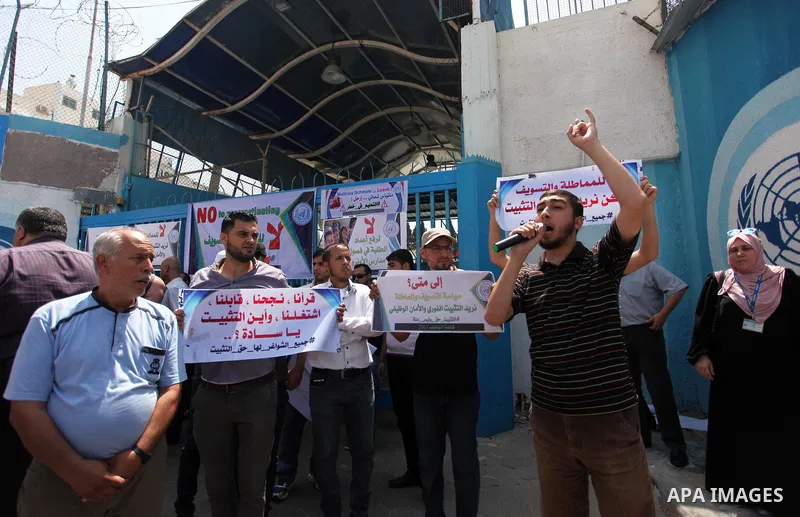 Palestinian employees of United Nations Relief and Works Agency (UNRWA) hold a sign during a protest against a U.S. decision to cut aid, in front of the headquarters UNRWA, in Gaza City on July 24, 2018. Photo by Mahmoud...