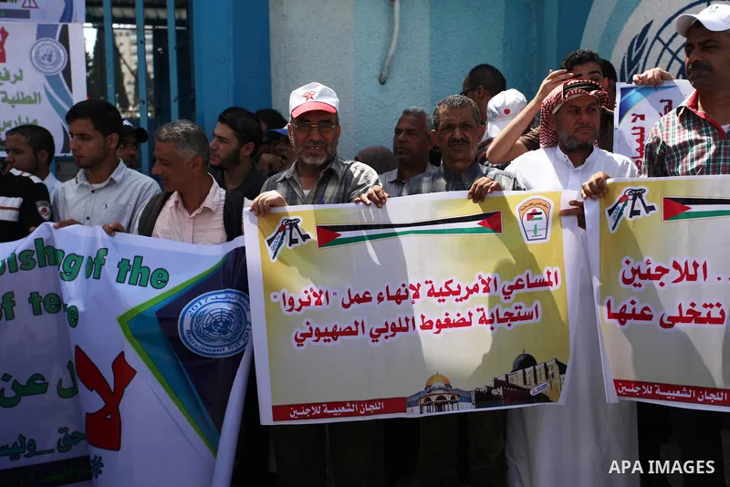 Palestinian employees of United Nations Relief and Works Agency (UNRWA) hold a sign during a protest against a U.S. decision to cut aid, in front of the headquarters UNRWA, in Gaza City on July 24, 2018. Photo by Mahmoud...