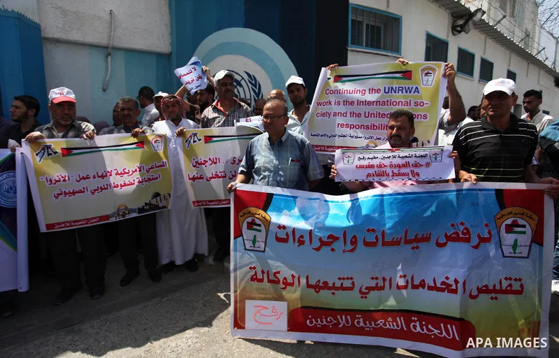 Palestinian employees of United Nations Relief and Works Agency (UNRWA) hold a sign during a protest against a U.S. decision to cut aid, in front of the headquarters UNRWA, in Gaza City on July 24, 2018. Photo by Mahmoud...