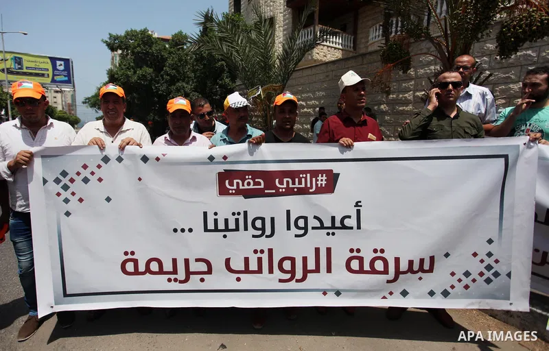 Palestinian Authority employees in the Gaza Strip take part in a protest demanding their salaries in front of the headquarters of the Council of Ministers, in Gaza city on July 24, 2018. Photo by Mahmoud Ajour