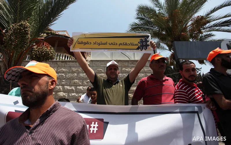 Palestinian Authority employees in the Gaza Strip take part in a protest demanding their salaries in front of the headquarters of the Council of Ministers, in Gaza city on July 24, 2018. Photo by Mahmoud Ajour