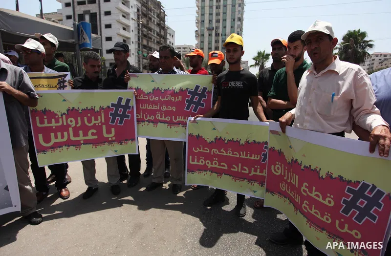 Palestinian Authority employees in the Gaza Strip take part in a protest demanding their salaries in front of the headquarters of the Council of Ministers, in Gaza city on July 24, 2018. Photo by Mahmoud Ajour