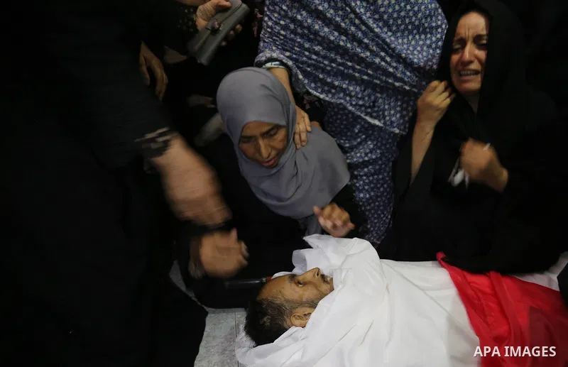 Relatives of Palestinian Majdi Oqeel, who died of wounds he sustained during clashes with Israeli troops, mourn over his body during his funeral, in Jabalia in the northern of Gaza Strip on July 24, 2018. Photo by Ashraf...