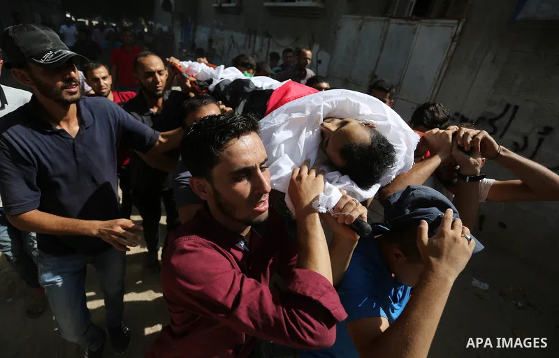Mourners carry the body of Palestinian Majdi Oqeel, who died of wounds he sustained during clashes with Israeli troops, during his funeral, in Jabalia in the northern of Gaza Strip on July 24, 2018. Photo by Ashraf Amra