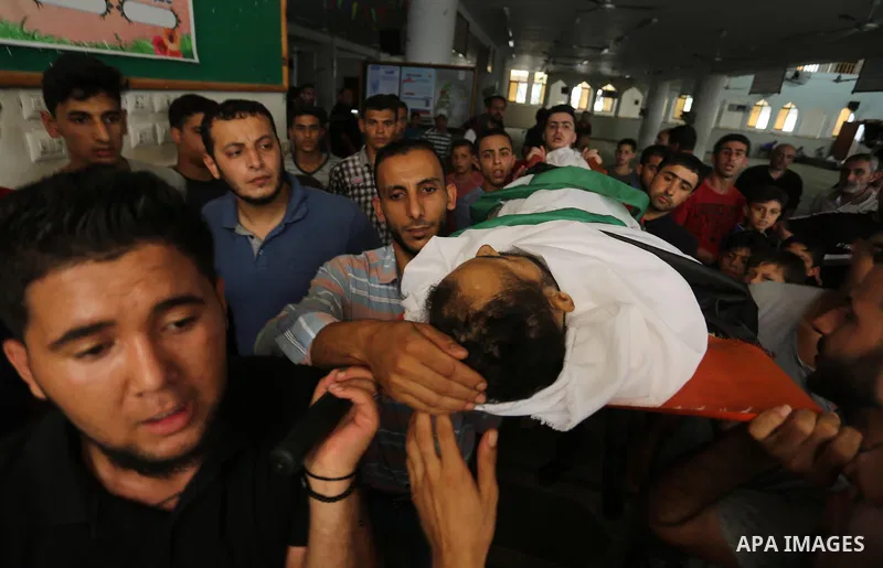 Mourners carry the body of Palestinian Majdi Oqeel, who died of wounds he sustained during clashes with Israeli troops, during his funeral, in Jabalia in the northern of Gaza Strip on July 24, 2018. Photo by Ashraf Amra