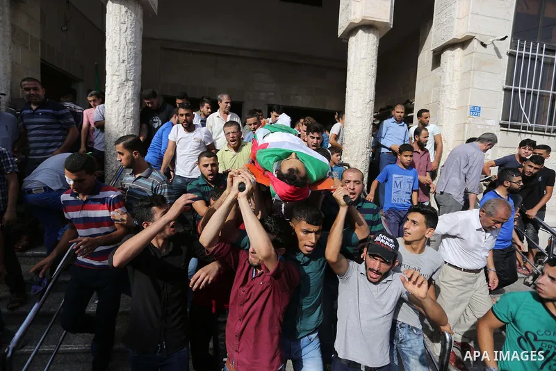 Mourners carry the body of Palestinian Majdi Oqeel, who died of wounds he sustained during clashes with Israeli troops, during his funeral, in Jabalia in the northern of Gaza Strip on July 24, 2018. Photo by Ashraf Amra