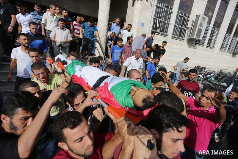 Mourners carry the body of Palestinian Majdi Oqeel, who died of wounds he sustained during clashes with Israeli troops, during his funeral, in Jabalia in the northern of Gaza Strip on July 24, 2018. Photo by Ashraf Amra