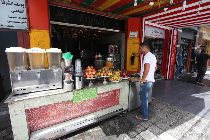 A Palestinian man buys ice-cream (sundae) during a heatwave in Gaza city on July 25, 2018. Photo by Mahmoud Ajour