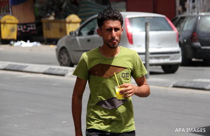 A Palestinian man buys ice-cream (sundae) during a heatwave in Gaza city on July 25, 2018. Photo by Mahmoud Ajour