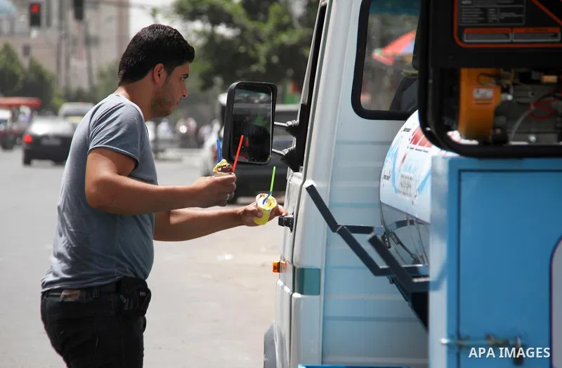 A Palestinian man buys ice-cream (sundae) during a heatwave in Gaza city on July 25, 2018. Photo by Mahmoud Ajour