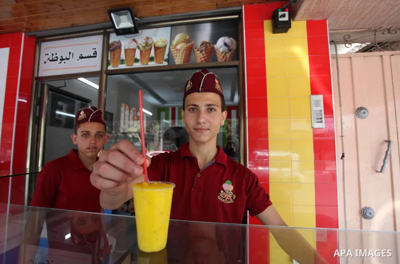 Palestinian vendors sell ice-cream (sundae) to customers during a heatwave in Gaza city on July 25, 2018. Photo by Mahmoud Ajour