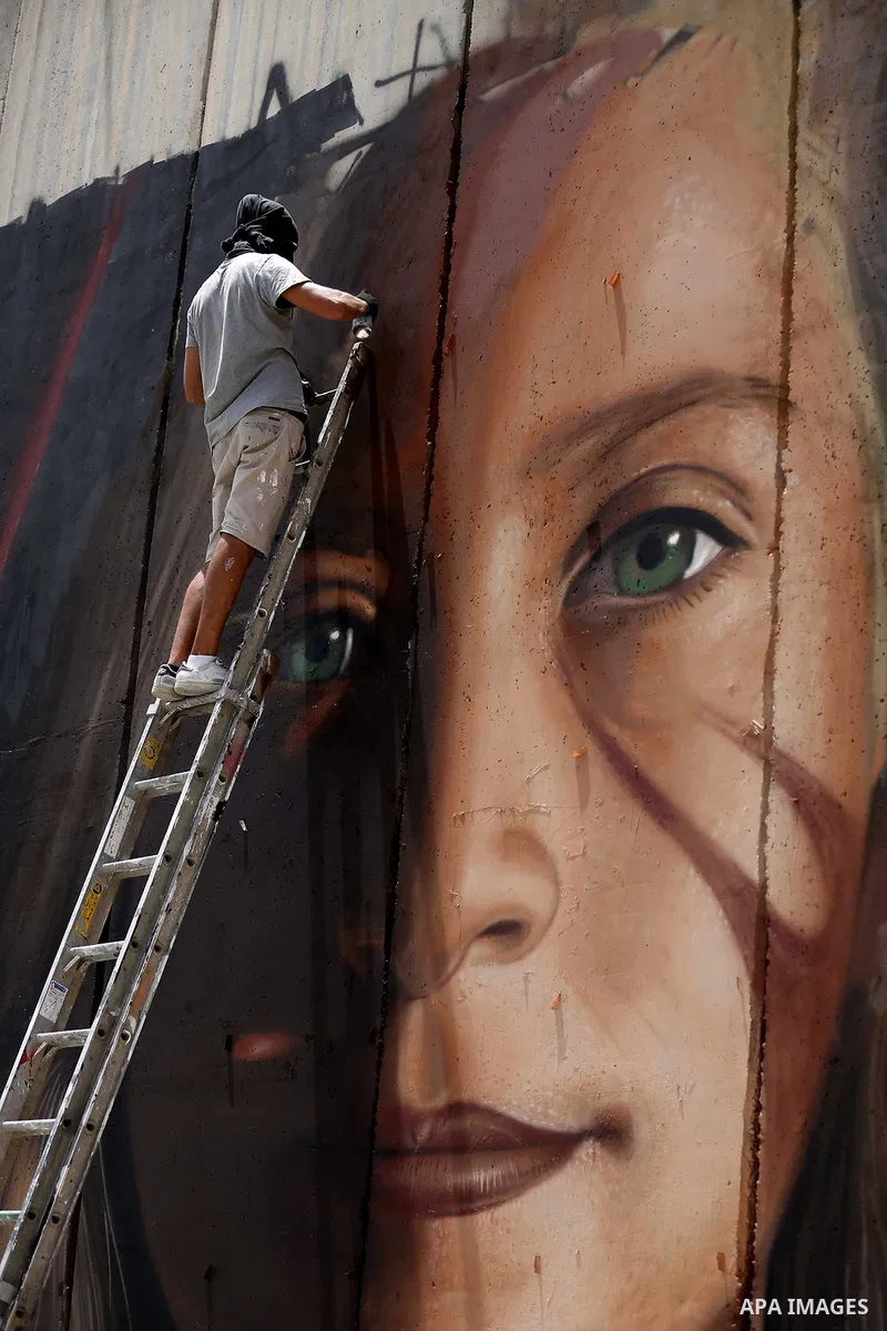 Italian artist Jorit Agoch paints a mural depicting Palestinian teenager Ahed Tamimi on Israel's controversial separation barrier in the West Bank city of Bethlehem, on July 25,2018. Tamimi, was charged earlier this year...