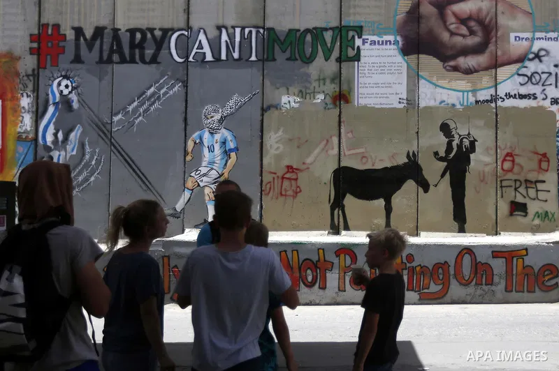 Italian artist Jorit Agoch paints a mural depicting Palestinian teenager Ahed Tamimi on Israel's controversial separation barrier in the West Bank city of Bethlehem, on July 25,2018. Tamimi, was charged earlier this year...
