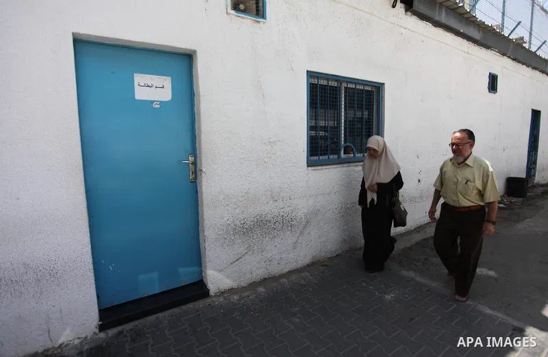 Palestinians walk past the closed gates of the headquarters United Nations Relief and Works Agency (UNRWA) during a strike in Gaza City, on July 26, 2018. Photo by Mahmoud Ajour