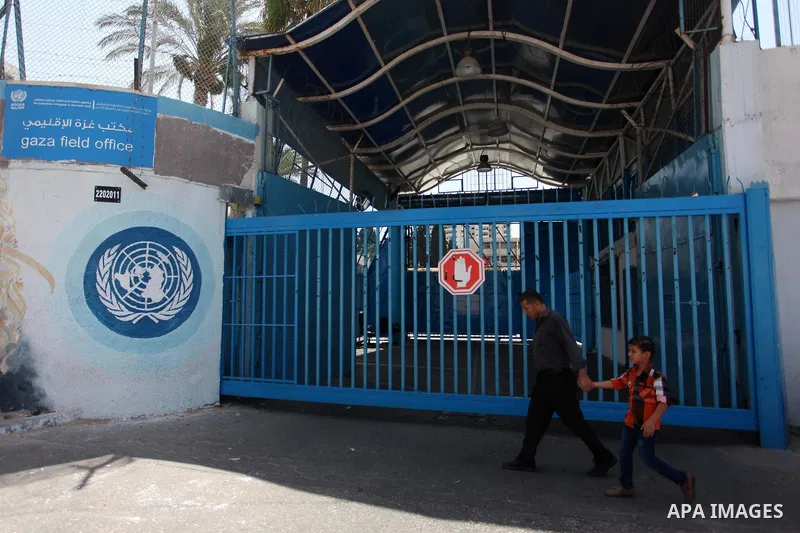 Palestinians walk past the closed gates of the headquarters United Nations Relief and Works Agency (UNRWA) during a strike in Gaza City, on July 26, 2018. Photo by Mahmoud Ajour
