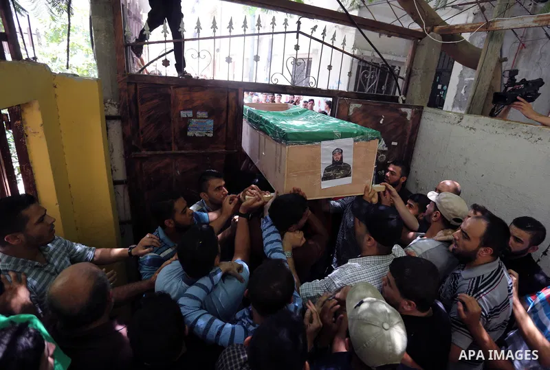 Mourners carry the body of Palestinian Hamas militant Obada Farwana, who was killed in Israeli tank fire, during his funeral in Gaza City on July 26, 2018. Photo by Ashraf Amra