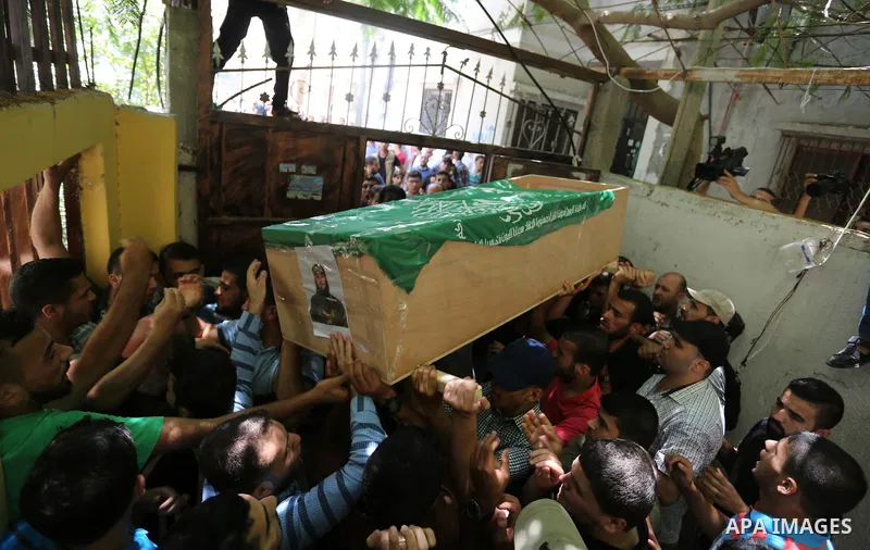 Mourners carry the body of Palestinian Hamas militant Obada Farwana, who was killed in Israeli tank fire, during his funeral in Gaza City on July 26, 2018. Photo by Ashraf Amra