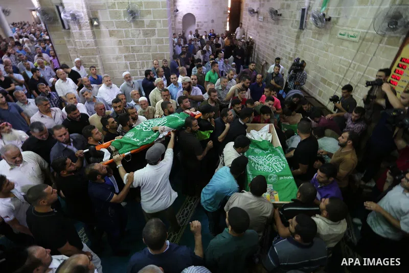 Mourners carry the bodies of Palestinian Hamas militants who were killed in Israeli tank fire, during their funeral at Omari Mosque in Gaza City July 26, 2018. Photo by Ashraf Amra