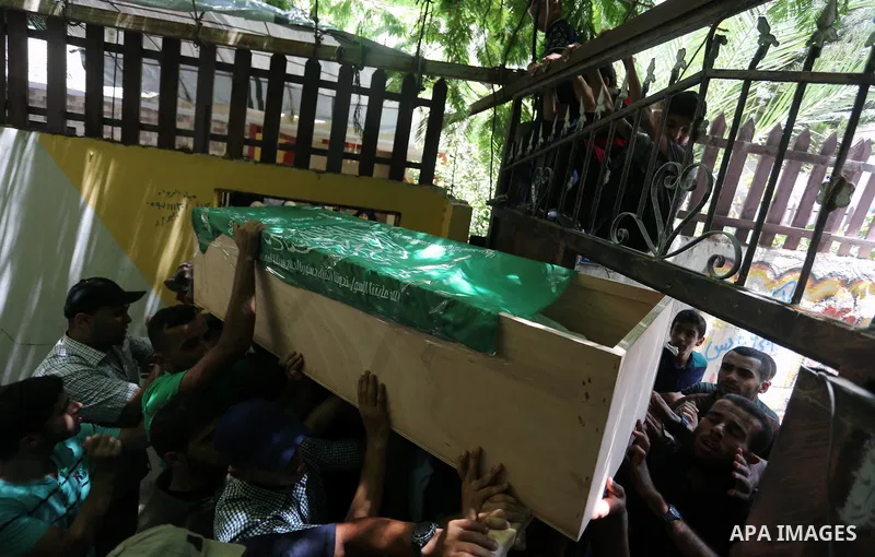 Mourners carry the body of Palestinian Hamas militant Obada Farwana, who was killed in Israeli tank fire, during his funeral in Gaza City on July 26, 2018. Photo by Ashraf Amra